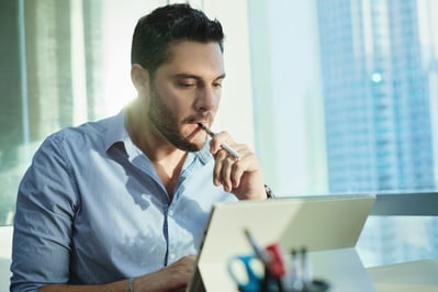 Male employee vapes while working on the computer