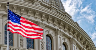 American flag flies in front of the United States Capitol building