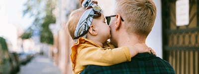father carries baby 