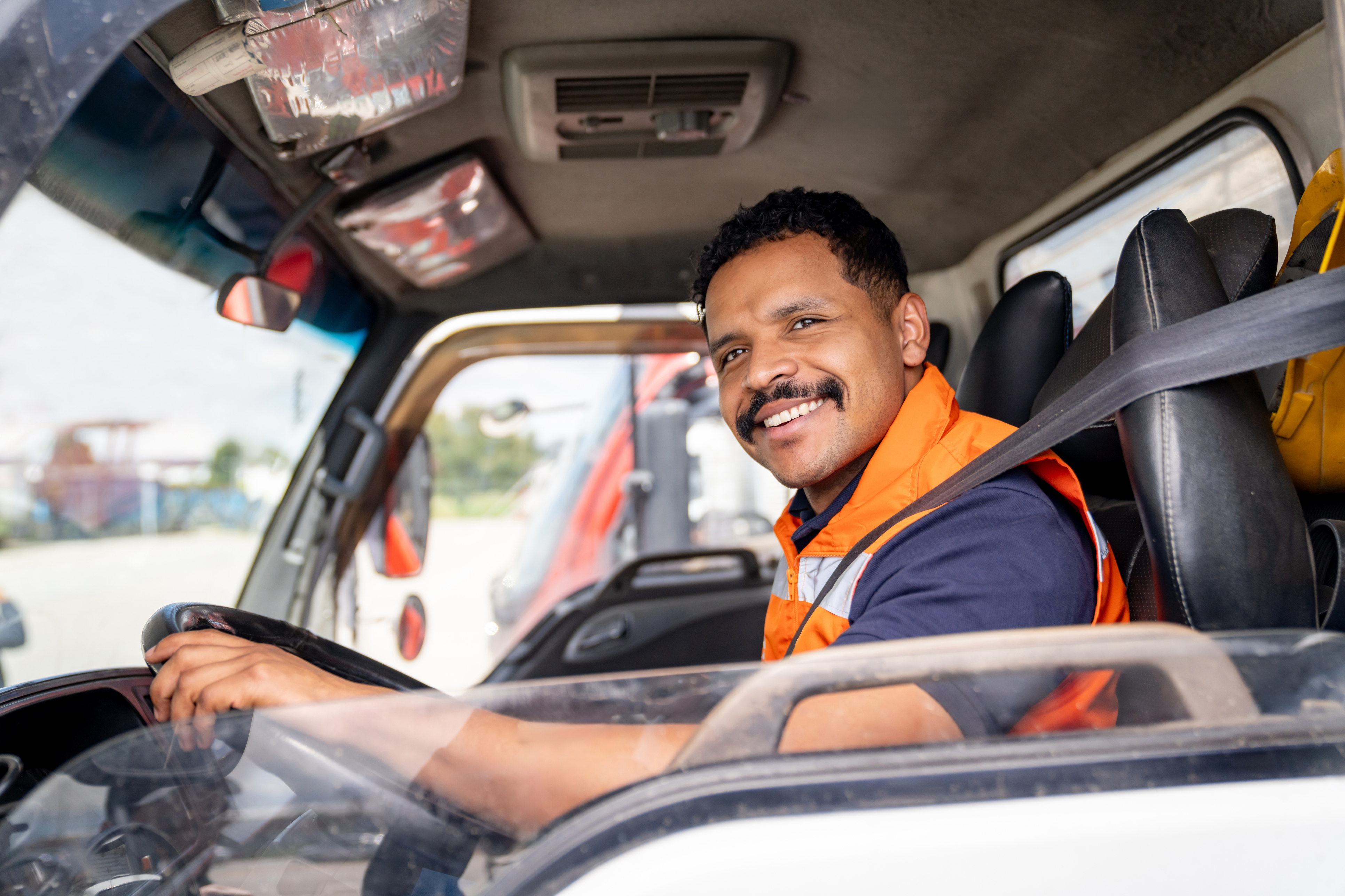 Happy man smiling while driving his truck for work stock photo