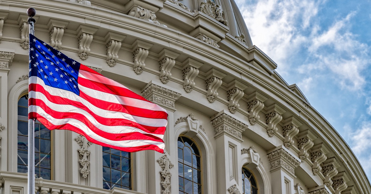 American flag flies in front of the United States Capitol building